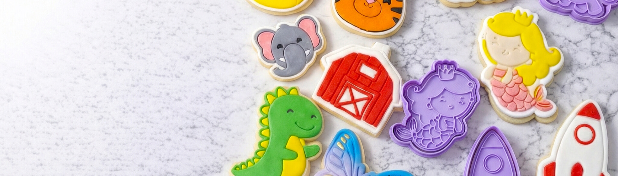 Cookie cutters and decorated cookies on marble surface